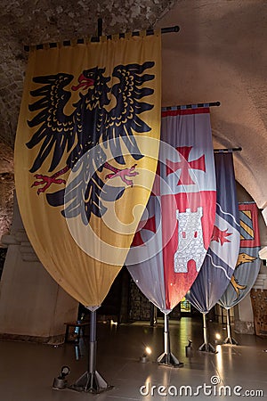 Vintage knightly flags in the hall of the Crusader fortress of the old city of Acre in northern Israel Editorial Stock Photo