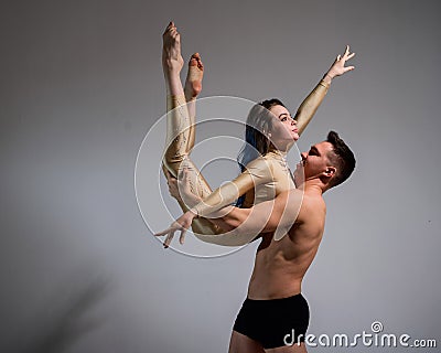 Acrobatic couple perform number on a white background. A duet of gymnasts rehearsing a performance with support. A man Stock Photo