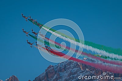 Acrobatic group of Freccia trecolori jet aeroplanes are performing maneouvres in a formation in the italian dolomites close to Editorial Stock Photo