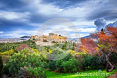 Acropolis with Parthenon. View through a frame with green plants, trees, ancient marbles and cityscape, Athens. Stock Photo