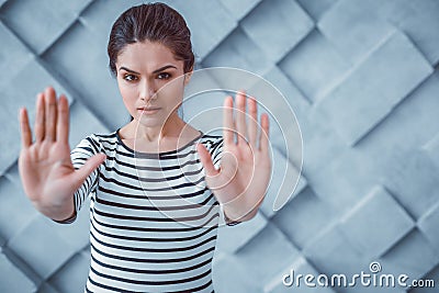 Dissent dark-haired woman pushing her hands forward Stock Photo