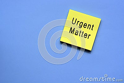 Urgent matter text on yellow sticky note with blue background Stock Photo