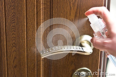 Actions to prevent the spread of COVID-19 coronavirus, door handle disinfection. Closeup of the hand wipes the door handle with a Stock Photo