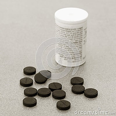 Activated Charcoal Tablets For Cleansing The Body On A Gray Background Closeup Stock Photo