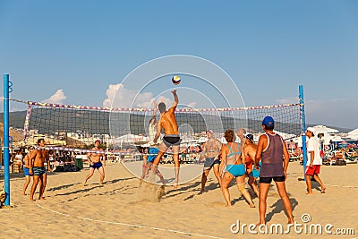 Active adults play the sport of volleyball on the sand beach Editorial Stock Photo