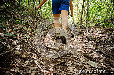 Active athlete climbs up the forest using special equipment for Nordic walking Stock Photo