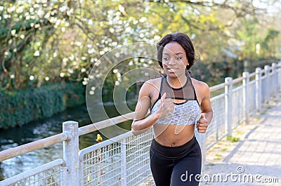 Active athletic young woman out jogging Stock Photo