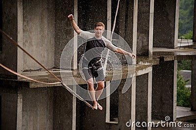 Active and brave young man balancing on a slackline Stock Photo