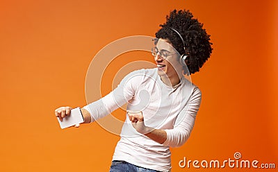 Active carefree black guy in wireless headphones enjoying music Stock Photo