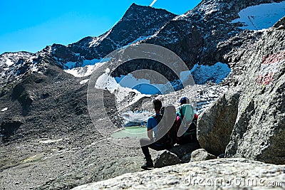 An active couple resting and enjoying the view on glacier lakes in the Hohe Tauern mountain chain in Carinthia, Austria Stock Photo