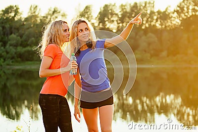 Active family at outdoor. two flexibility curly blonde beautiful woman twin sisters in stylish sportswear have a rest Stock Photo