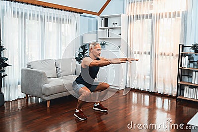 Active and fit senior man warmup and stretching before home exercising. Clout Stock Photo