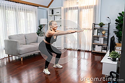 Active and fit senior woman warmup and stretching before home exercising. Clout Stock Photo