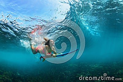 Active girl in bikini in dive action on surf board Stock Photo