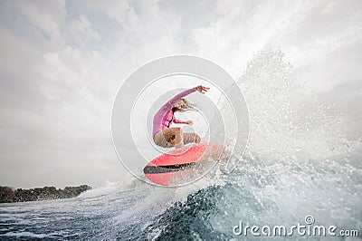 Active girl jumping on the orange wakeboard Stock Photo