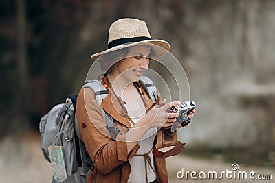 Active healthy Caucasian woman taking pictures with an vintage film camera on a forest rocks Stock Photo