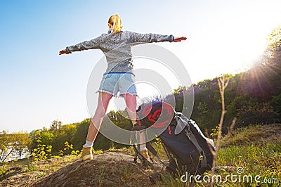 Active healthy woman hiking in beautiful forest. Happy young woman resting of forest clearing during hike holidays. Stock Photo