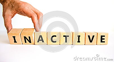 Active or inactive symbol. Businessman turns wooden cubes and changes the word Inactive to Active. Beautiful white table white Stock Photo
