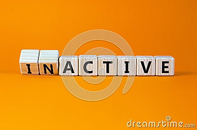 Active or inactive symbol. Turned wooden cubes and changed the concept word Inactive to Active. Beautiful orange table orange Stock Photo