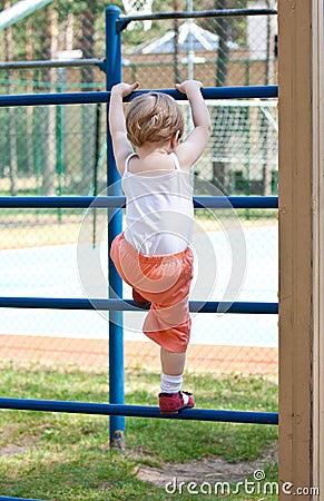 Active little girl climbing on a ladder Stock Photo