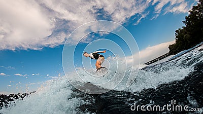 active man with an amputated hand ride the wave on wakeboard Stock Photo