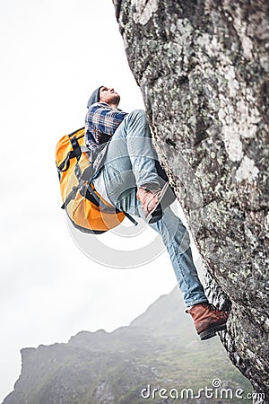 Active man tourist wearing professional backpack to climb on the rock Stock Photo