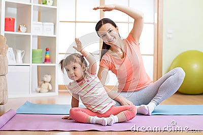 Active mother and child daughter are engaged in fitness, yoga, exercise at home Stock Photo