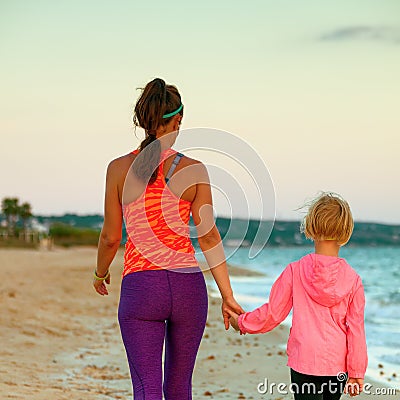Active mother and child on seacoast in evening walking Stock Photo