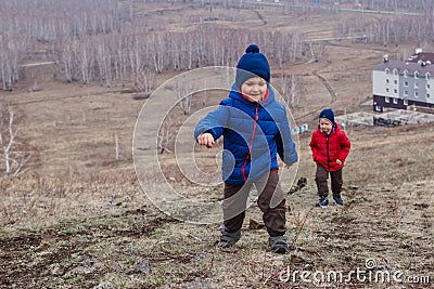 Active preschool children climb the path to the high mountain in spring, spring landscape Stock Photo