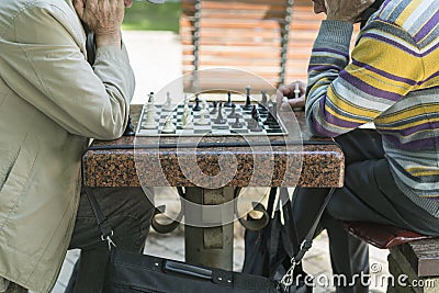 Active retired people, old friends and free time, two seniors having fun and playing chess game at park. Old men are playing chess Editorial Stock Photo