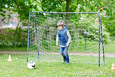 Active school kid boy playing soccer and kicking ball. Stock Photo