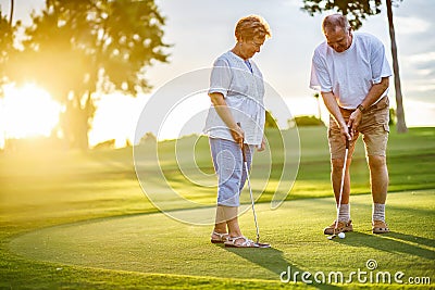 Active senior lifestyle, elderly couple playing golf together Stock Photo