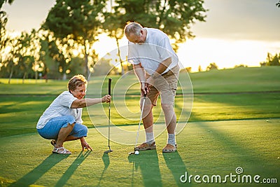 Active senior lifestyle, elderly couple playing golf together Stock Photo