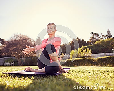 Active senior woman doing a yoga twist outdoors Stock Photo