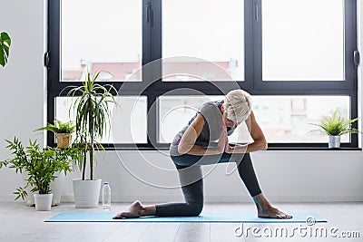 Active senior woman practicing yoga indoors Stock Photo