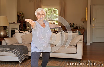 Active senior woman smiling and doing yoga alone at home Stock Photo