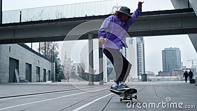 Sporty skater making trick on board outdoor. Skateboard rolling on asphalt. Stock Photo