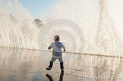Active small kid escaping from huge water wave in city during storm weather Stock Photo