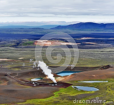 Active steam stack and parts of Krafla geothermal power plant next by the volcano crater with Krafla Viti lake in Nordurland Stock Photo