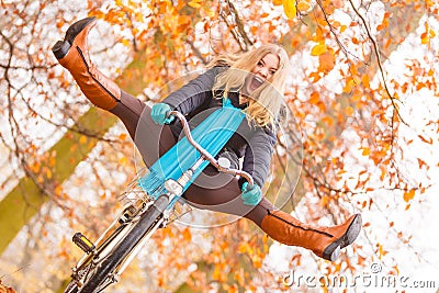 Active woman having fun riding bike in autumn park Stock Photo