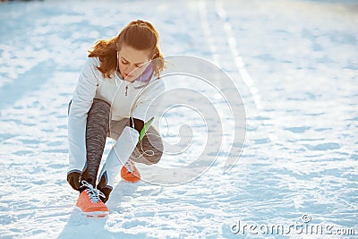 Active woman in white jacket tying your shoelaces Stock Photo