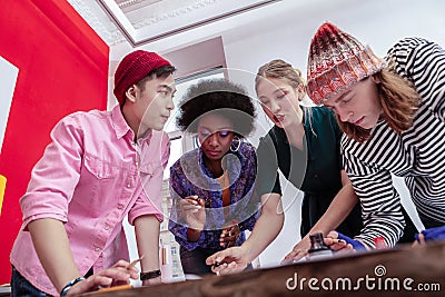 Four young active workers of company having brainstorming Stock Photo