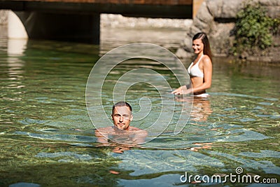 Active young couple plays in shallow water on a hot summer morning Stock Photo