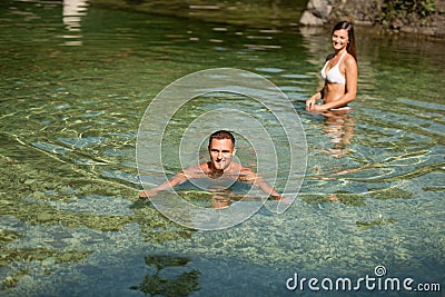 Active young couple plays in shallow water on a hot summer morning Stock Photo