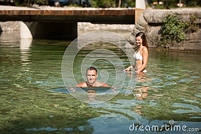 Active young couple plays in shallow water on a hot summer morning Stock Photo