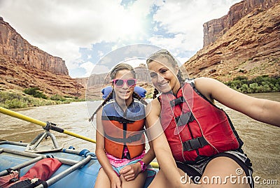 Active young family enjoying a fun whitewater rafting trip Stock Photo