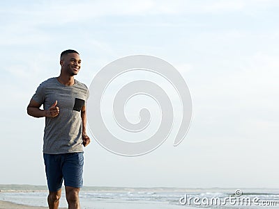 Active young man jogging at the beach Stock Photo