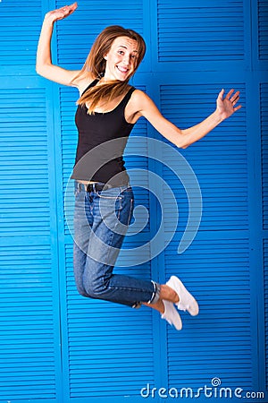 Activity and happiness concept - smiling teenage girl in white blank t-shirt jumping Stock Photo