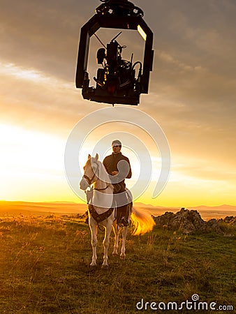 Actor riding a horse during the filming of a sequence for a television series,with camera on crane Editorial Stock Photo