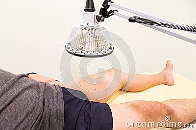 Acupuncture patient being treated with needles and infrared heat Stock Photo